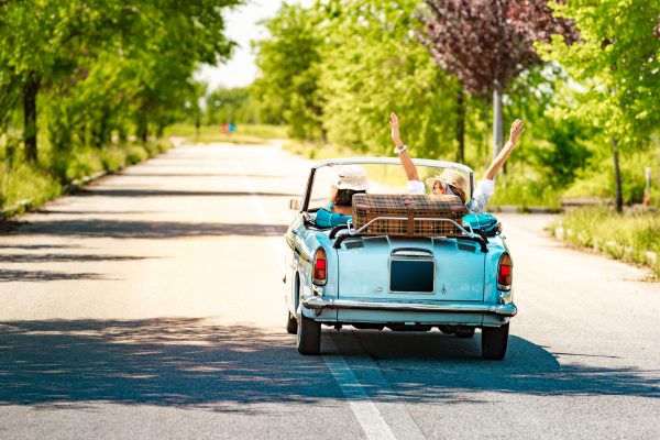 Happy Mature Couple leaving for a Romantic Road trip Vacation with a Vintage car